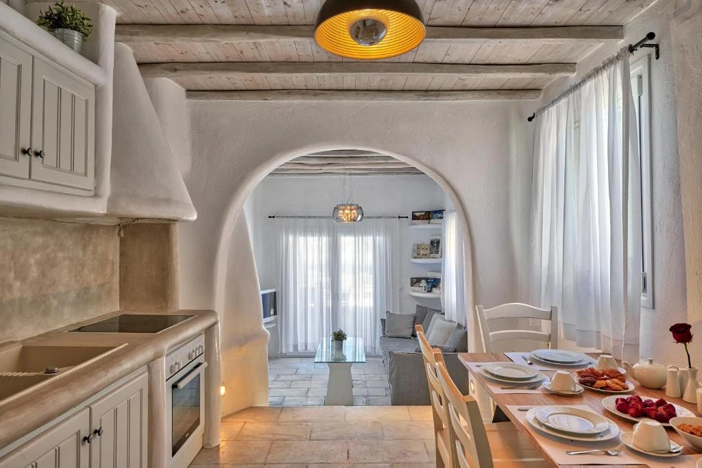 Nalu Villa’s fully equipped kitchen and dining table beneath wooden ceiling beams